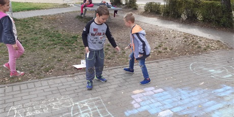 Powiększ grafikę: dzieci rysują kredą na chodniku