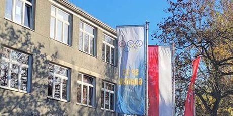 Powiększ grafikę: Budynek szkoły z flagami