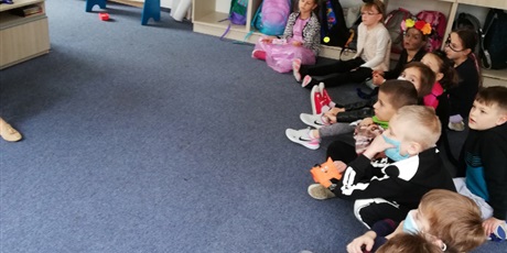 Powiększ grafikę: dzieci na podłodze słuchają nauczyciela