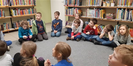 Powiększ grafikę: dzieci siedzą na dywanie  i słuchają nauczyciela