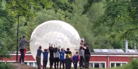 Powiększ grafikę: Uczniowie toczą ogromny balon