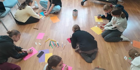 Powiększ grafikę: uczniaowie siedzacy na podłodze w sali lekcyjnej