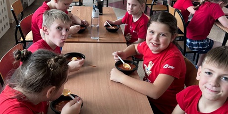 Powiększ grafikę: uczniowie jedzą pyszną zupę