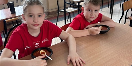 Powiększ grafikę: uczniowie jedzą pyszną zupę