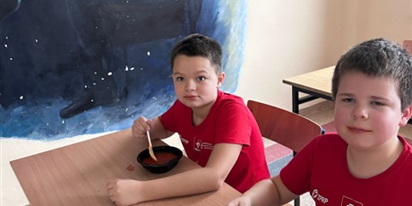 Powiększ grafikę: uczniowie jedzą pyszną zupę