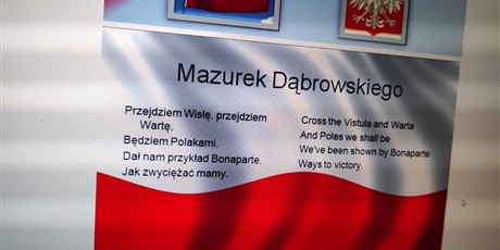 Powiększ grafikę: treść Hymnu Polskiego na tle  biało czerwonej flagi