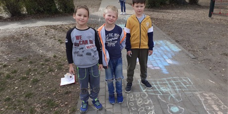 Powiększ grafikę: dzieci rysują kredą po chodniku
