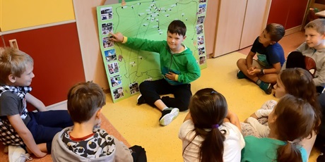 Powiększ grafikę: Uczeń pokazuje na mapie Polski, gdzie był w czasie wakacji.