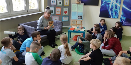 Powiększ grafikę: Pani Jola czyta dzieciom książkę.