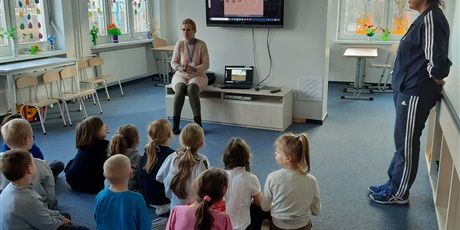 Powiększ grafikę: dzieci na podłodze słuchają nauczyciela