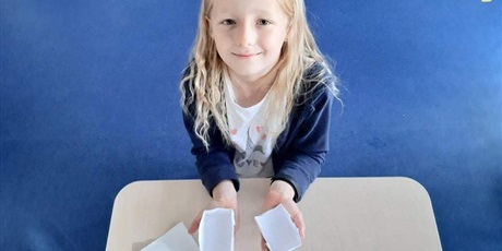 Powiększ grafikę: Dziewczynka prezentuje wykonane papierowe pudełeczka.